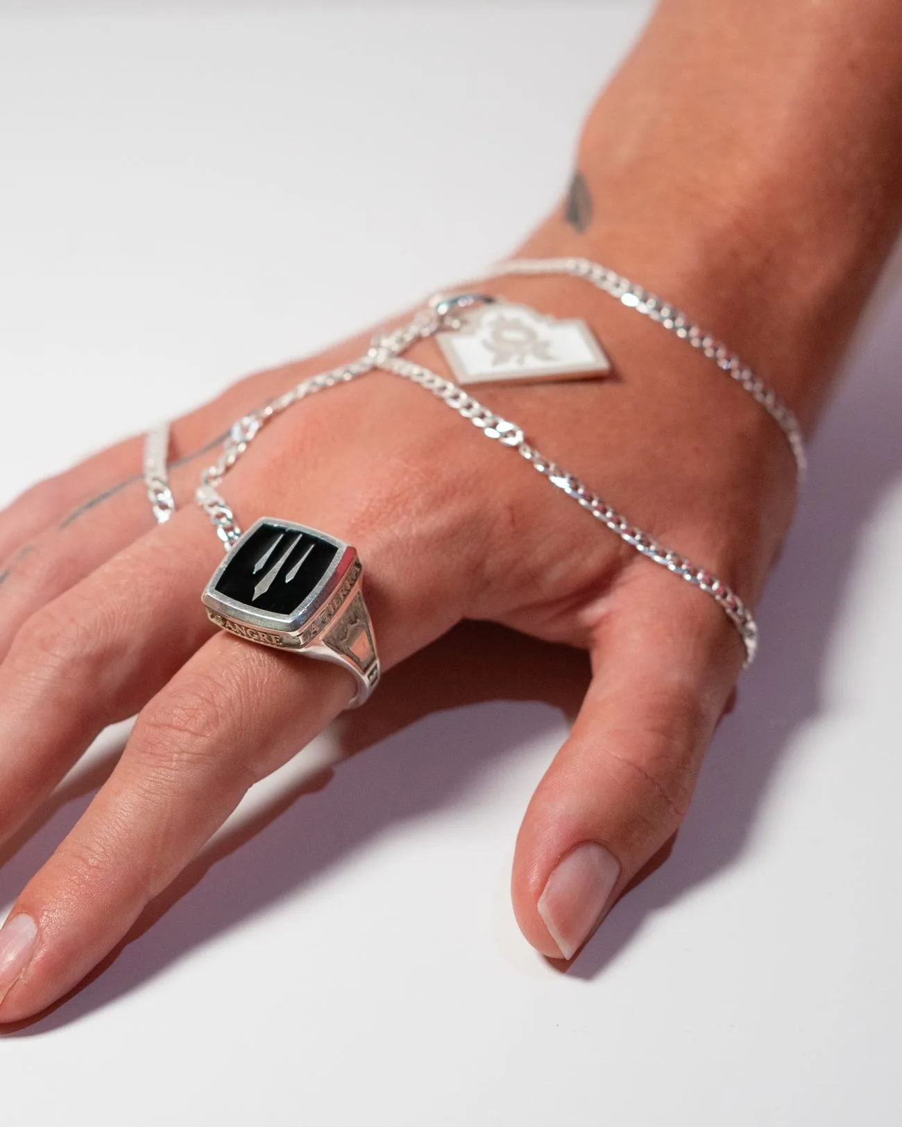 Mano con anillo de sello y cadena de plata