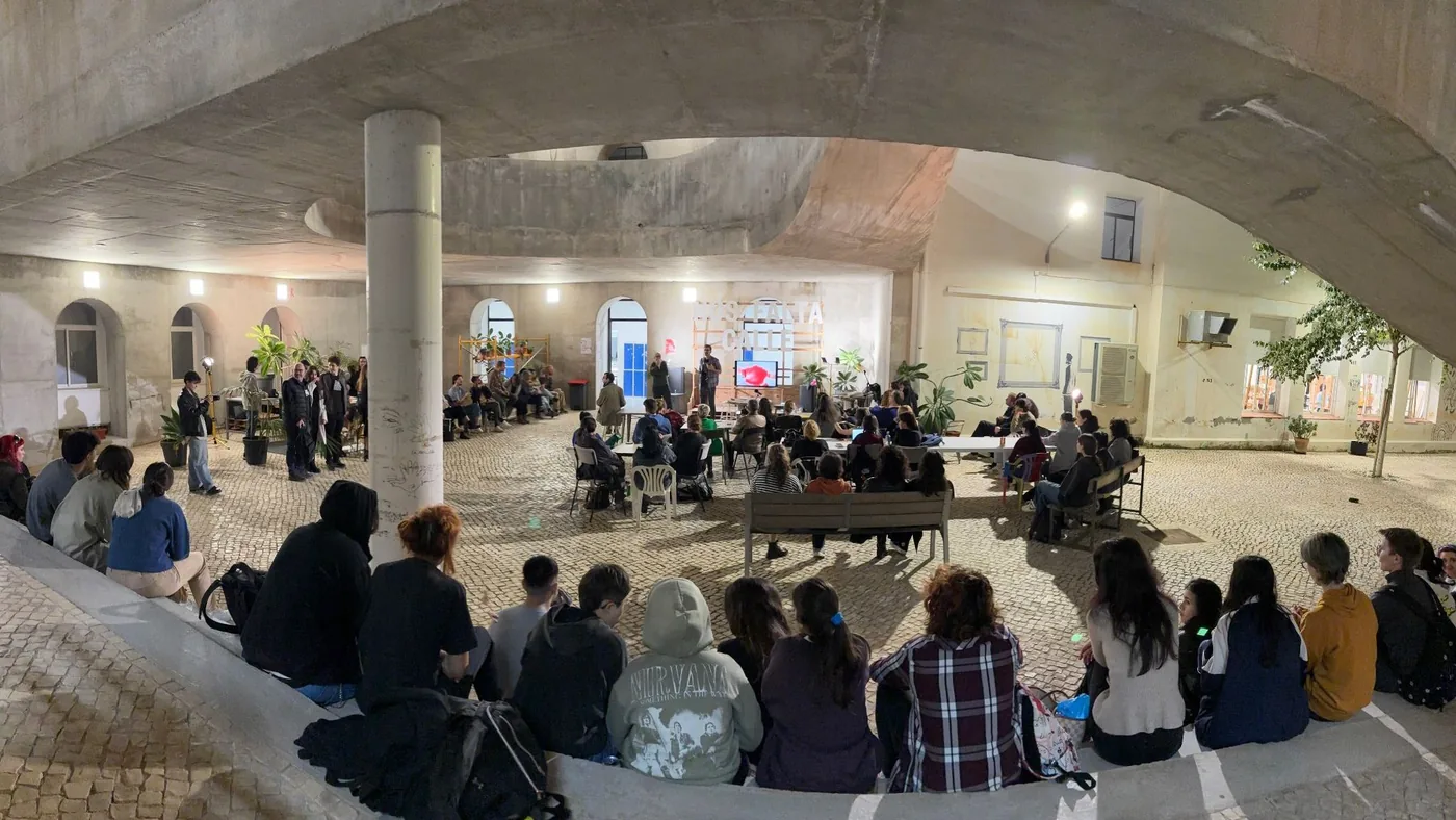 Encuentro de Surtopías al anochecer en un patio porticado lleno de asistentes